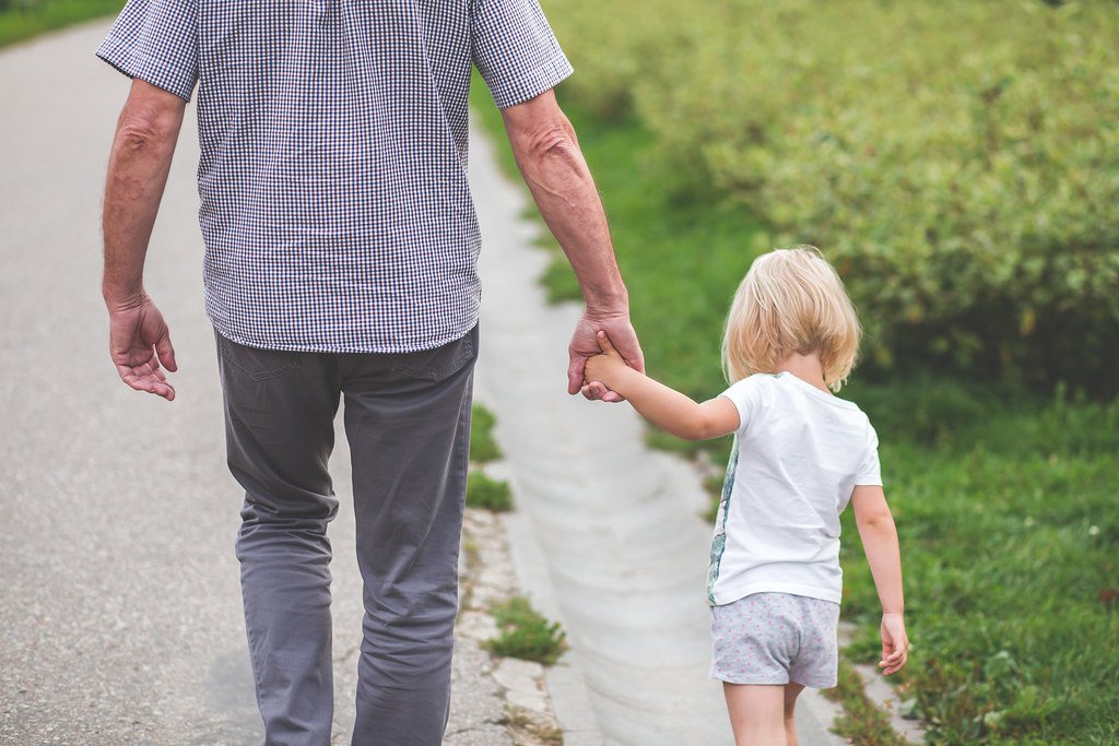 Grand-père et petite-fille se tenant la main, illustrant la transmission d'un capital d'assurance vie entre générations