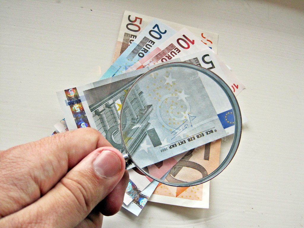 Billets en euros examinés à la main, illustrant un rachat sur un contrat d'assurance vie
